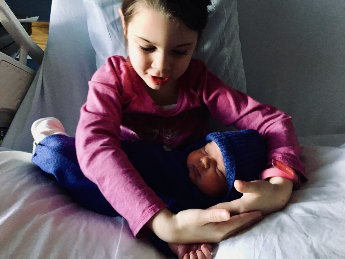Iona holding a sleeping newborn in her arms